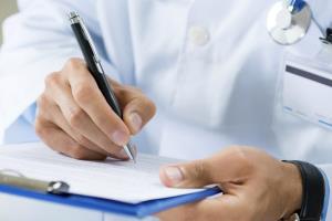 doctor writes with pen on document illustrating patient safety